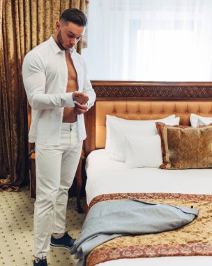 Otel odasında beyaz elbiseli Genç adam