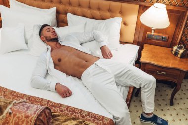 Otel odasında zaman dinlendirici beyaz elbiseli Genç adam