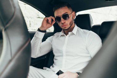 Lüks araba arka koltukta otururken yakışıklı işadamı