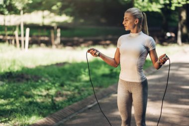 Park ip atlama ile uygun genç kadın portresi. Fitness erkek güneşli günde Park açık havada egzersiz yapıyor.