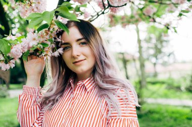 Park güneşli günde kiraz çiçeği mevsiminde zevk güzel genç kadın