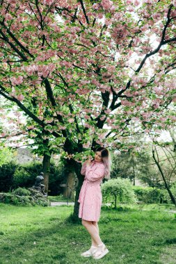 Bahçede yürüyüş kırmızı şeritli elbiseli Genç kadın