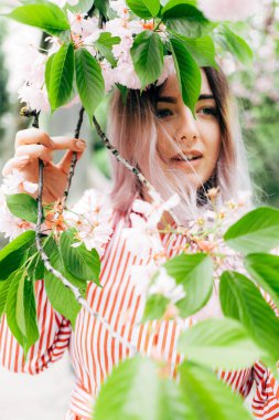 Park güneşli günde kiraz çiçeği mevsiminde zevk güzel genç kadın