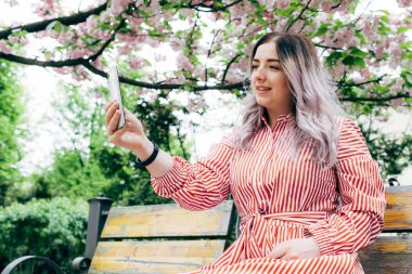 Park güneşli günde kiraz çiçeği mevsiminde zevk güzel genç kadın