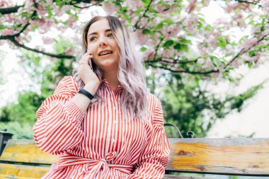 Park güneşli günde kiraz çiçeği mevsiminde zevk güzel genç kadın