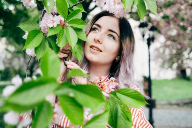 Park güneşli günde kiraz çiçeği mevsiminde zevk güzel genç kadın