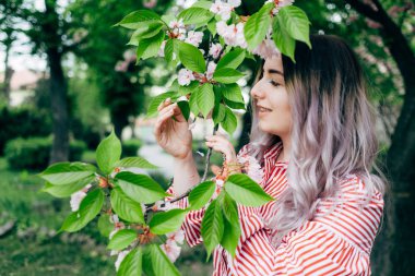 Park güneşli günde kiraz çiçeği mevsiminde zevk güzel genç kadın