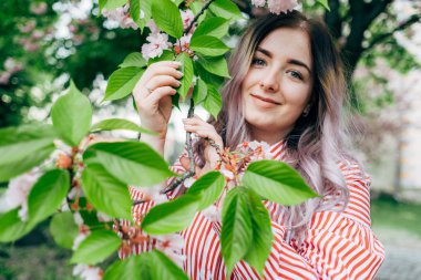 Park güneşli günde kiraz çiçeği mevsiminde zevk güzel genç kadın
