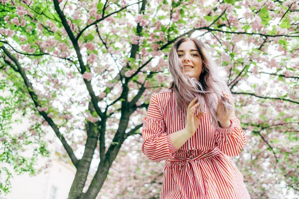 Park güneşli günde kiraz çiçeği mevsiminde zevk güzel genç kadın