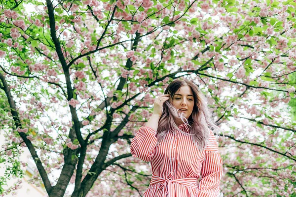 Park güneşli günde kiraz çiçeği mevsiminde zevk güzel genç kadın