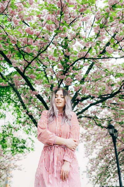 Park güneşli günde kiraz çiçeği mevsiminde zevk güzel genç kadın