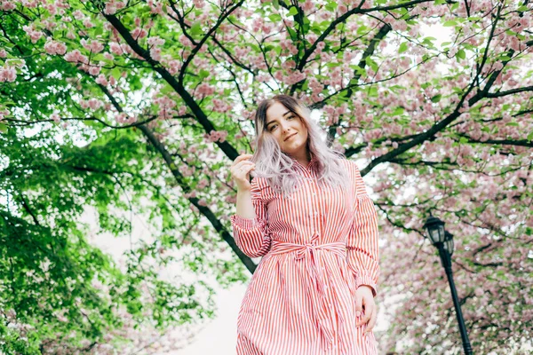 Park güneşli günde kiraz çiçeği mevsiminde zevk güzel genç kadın