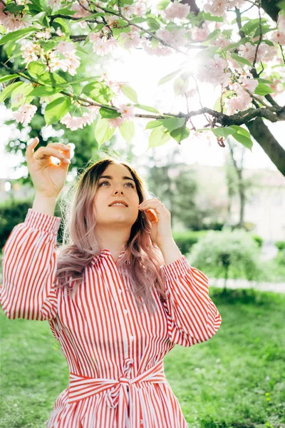 Park güneşli günde kiraz çiçeği mevsiminde zevk güzel genç kadın