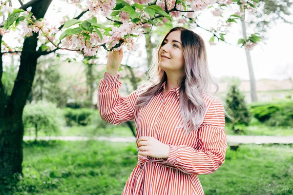 Park güneşli günde kiraz çiçeği mevsiminde zevk güzel genç kadın