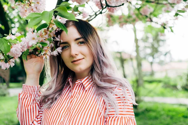Park güneşli günde kiraz çiçeği mevsiminde zevk güzel genç kadın