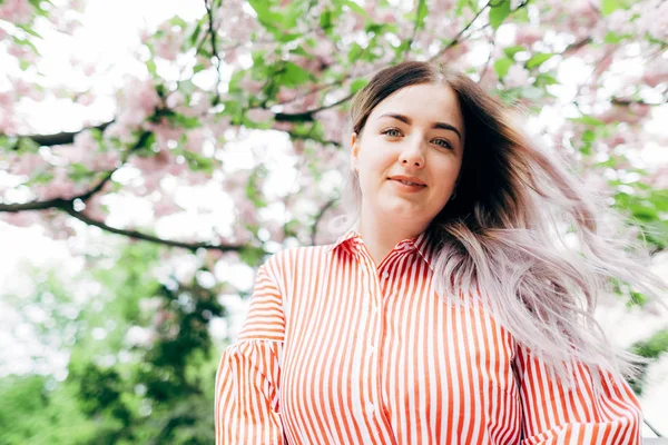 Park güneşli günde kiraz çiçeği mevsiminde zevk güzel genç kadın