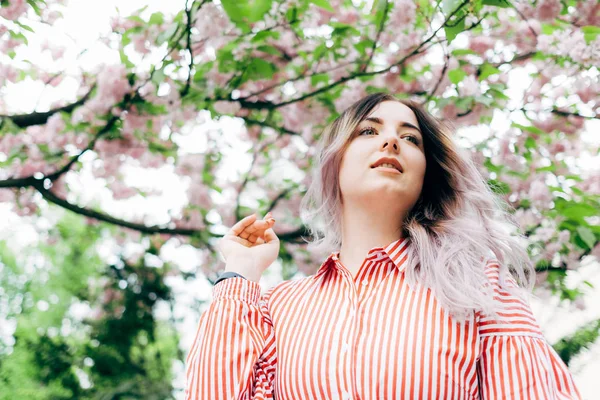 Park güneşli günde kiraz çiçeği mevsiminde zevk güzel genç kadın