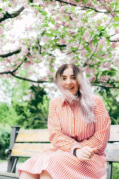 Park güneşli günde kiraz çiçeği mevsiminde zevk güzel genç kadın