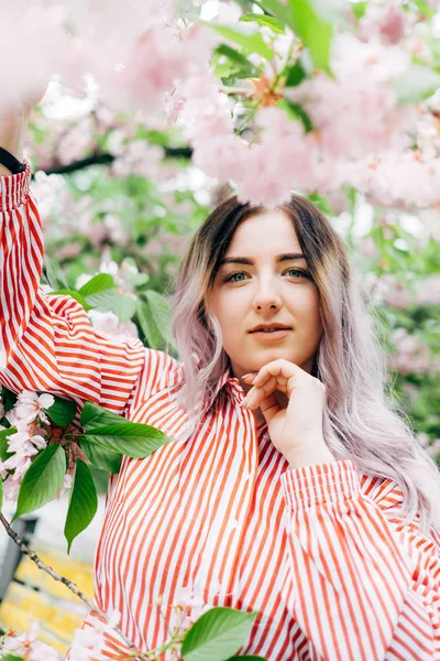Park güneşli günde kiraz çiçeği mevsiminde zevk güzel genç kadın