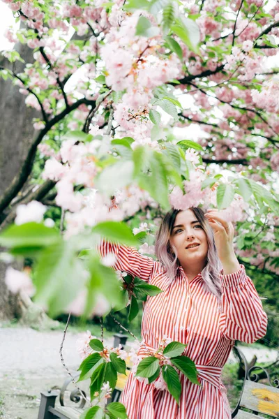 Park güneşli günde kiraz çiçeği mevsiminde zevk güzel genç kadın
