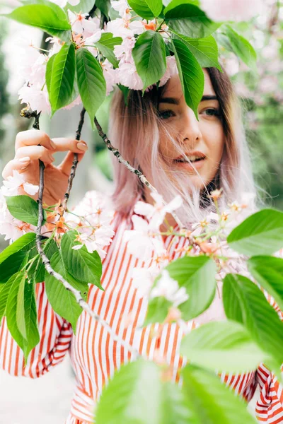 Park güneşli günde kiraz çiçeği mevsiminde zevk güzel genç kadın