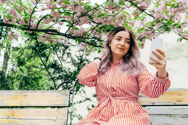 Park güneşli günde kiraz çiçeği mevsiminde zevk güzel genç kadın