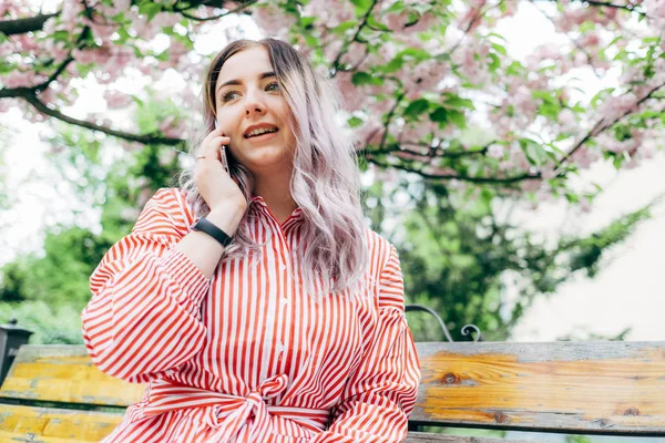 Park güneşli günde kiraz çiçeği mevsiminde zevk güzel genç kadın