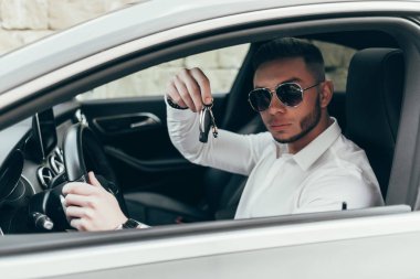Yakışıklı genç adam onun yeni araba anahtarları gösterilen lüks aracın içinde oturan Auto satın
