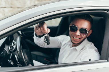 Yakışıklı genç adam onun yeni araba anahtarları gösterilen lüks aracın içinde oturan Auto satın