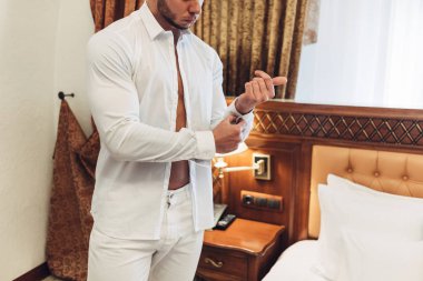 Otel odasında beyaz elbiseli Genç adam