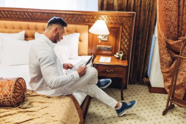 Otel odasında zaman dinlendirici beyaz elbiseli Genç adam