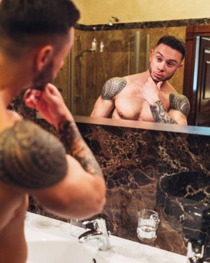 Genç kaslı adam banyoda kalıyorum beyaz gömlekli