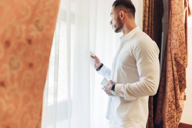 Otel odasında beyaz elbiseli Genç adam