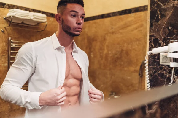 Genç kaslı adam banyoda kalıyorum beyaz gömlekli
