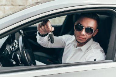 Yakışıklı genç adam onun yeni araba anahtarları gösterilen lüks aracın içinde oturan Auto satın