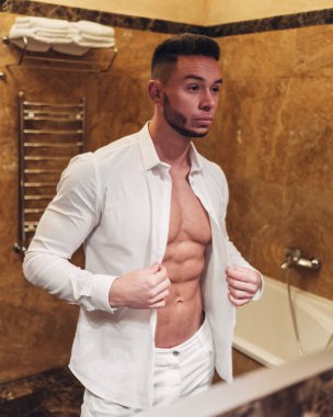Genç kaslı adam banyoda kalıyorum beyaz gömlekli