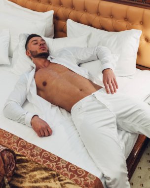 Otel odasında zaman dinlendirici beyaz elbiseli Genç adam