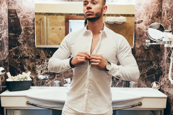 Genç kaslı adam banyoda kalıyorum beyaz gömlekli