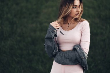 Genç ve güzel kadın sokakta rahat kıyafetler portresi. Pembe gömlek ve pantolon giymiş. Bahar, yaz konsepti. Zaman rahatla. Güneş gözlüklü kız. Şehir Günbatımı keyfini çıkarın.