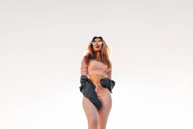 Genç ve güzel kadın sokakta rahat kıyafetler portresi. Pembe gömlek ve pantolon giymiş. Bahar, yaz konsepti. Zaman rahatla. Güneş gözlüklü kız. Şehir Günbatımı keyfini çıkarın.