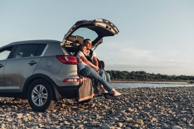 Mutlu çift Roadtrip Suv arabada batımına üzerinde