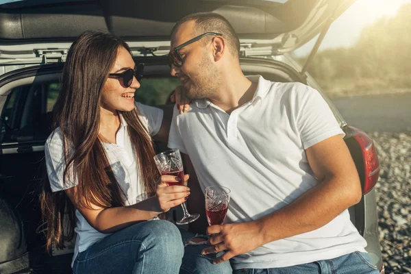Happy Traveler Couple on Picnic into the Sunset with SUV Car