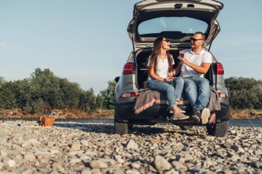 Mutlu Traveler çift üzerinde Suv araba batımına piknik