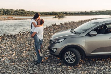Mutlu çift Roadtrip Suv arabada batımına üzerinde