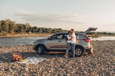 Mutlu çift Roadtrip Suv arabada batımına üzerinde