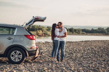 Mutlu çift Roadtrip Suv arabada batımına üzerinde