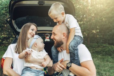 Piknik ormanda, Aile hafta sonu kavramı, dört kişi yaz zevk küçük çocukları ile birlikte genç çift
