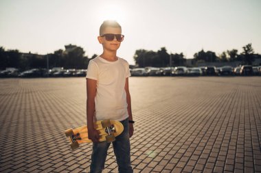 Sevimli küçük adam elinde kaykay ile