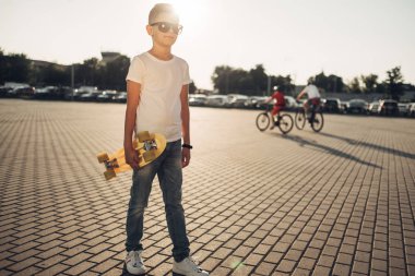 Sevimli küçük adam elinde kaykay ile