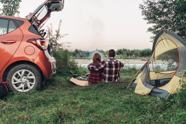 Mutlu genç çift doğa üzerinde piknik şenlik ateşi başına oturmuş